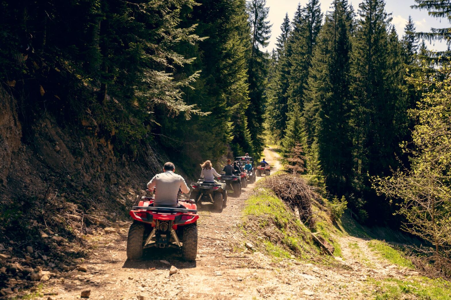 a line of ATV's riding on a trial in the mountains